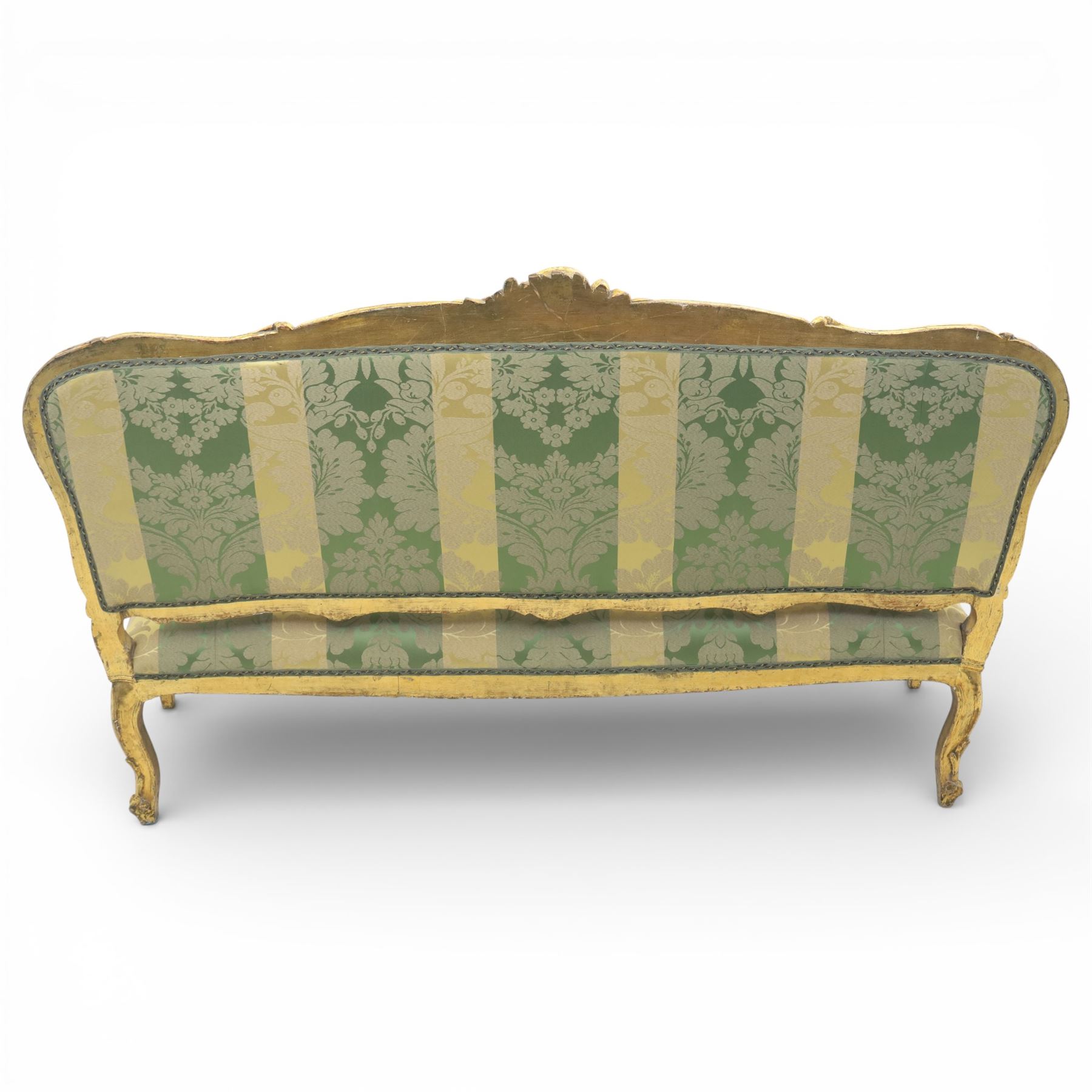 20th century French Louis XV style giltwood salon sofa, with shaped and moulded serpentine cresting rail carved with central scroll motif, padded back and seat upholstered in green and gold striped damask fabric, scroll carved open arms with padded rests, shaped apron carved with rocaille and foliate motifs, raised upon cabriole legs