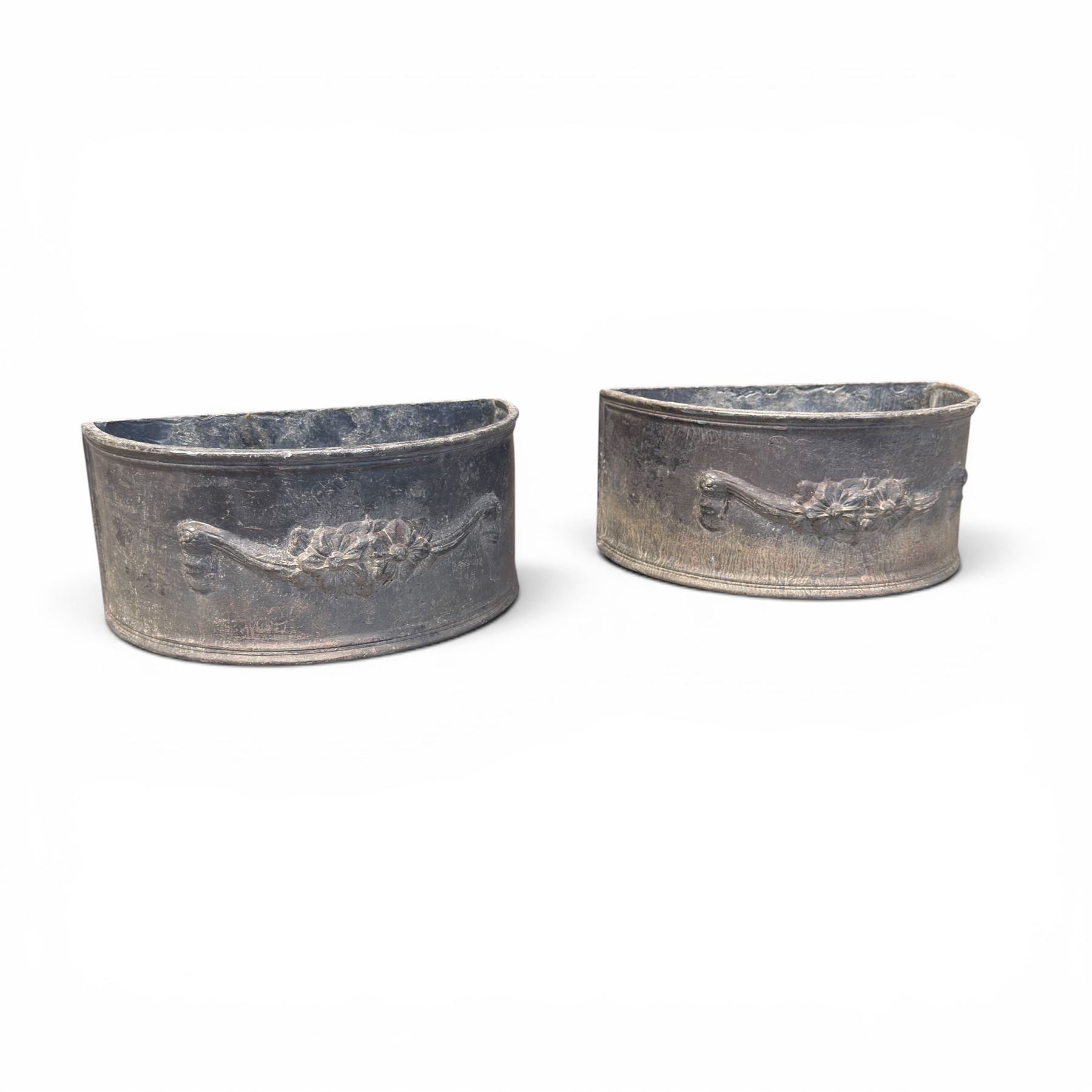 Pair of 19th century decorative lead planters of demi-lune form, decorated with raised relief floral swag decoration