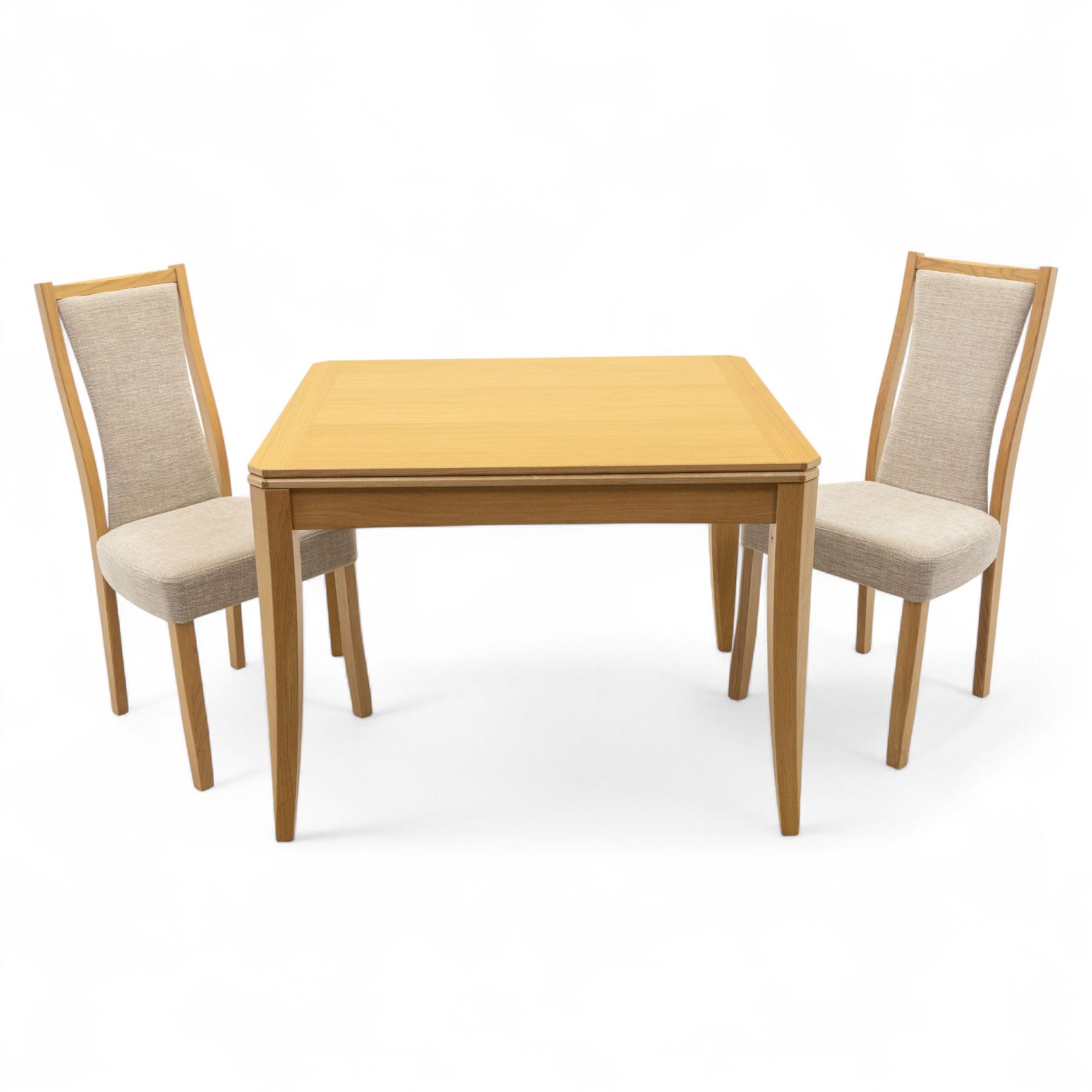 Ercol - light oak ‘Artisan’ rectangular dining table with chamfered top extending fold over top and tapered legs, together with two matching high back dining chairs upholstered in textured beige fabric (Chairs H 98cm, W 47cm, D 52cm)