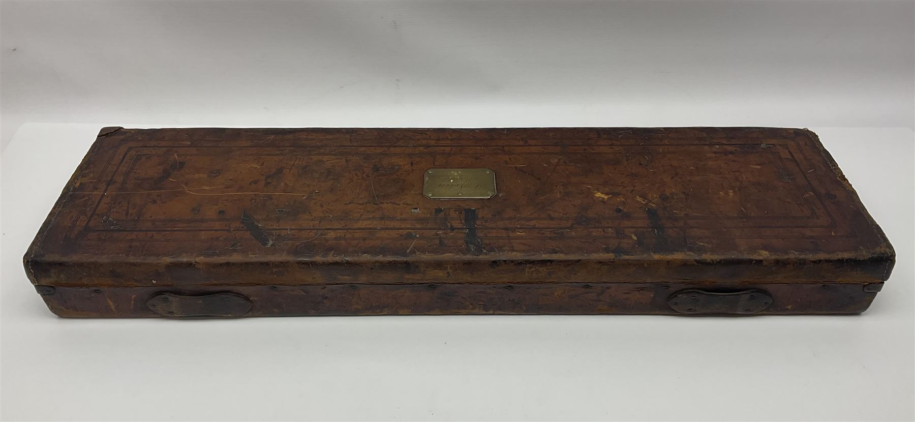 Leather shotgun case, the red baize lined interior with the trade labels of Westley Richards & Co., London, a brass plaque inscribed 'T Nevin, Mirfield, Yorkshire' to cover, with key, case to fit barrel 76cm (30 inches)  
