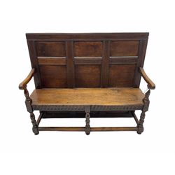 George III oak panelled back settle, the arms with scroll carved terminals on turned supports, arcade carved frieze and return rails, joined by plain stretchers