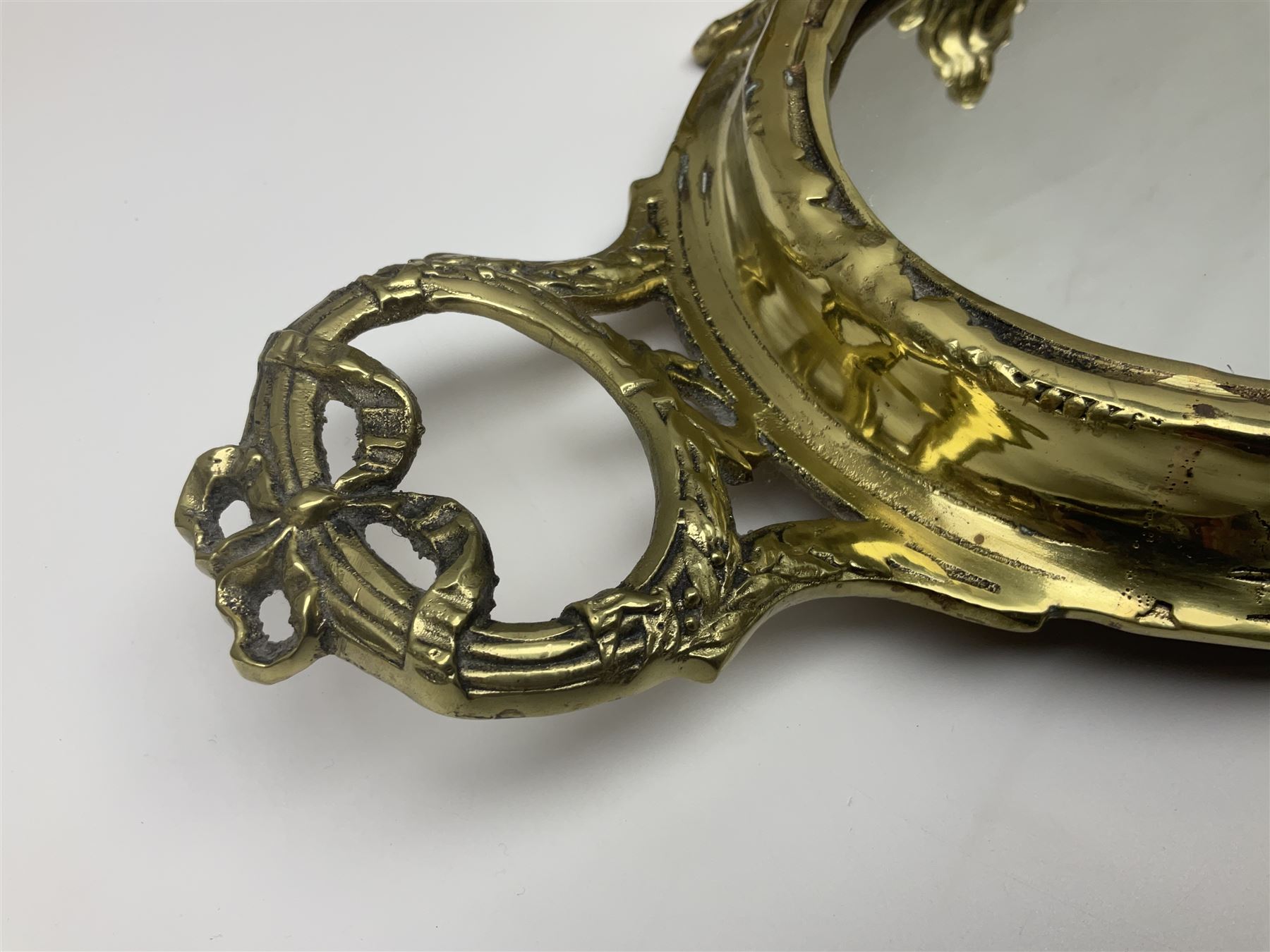 Ornate brass centrepiece, with twin handled vase upon a mirrored base, with floral and scrolling decoration, H23cm 