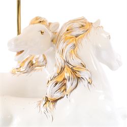 Italian-style ceramic table-lamp featuring two white running horses with gold accents, with cream tasselled lampshade, upon a wooden base, approx. H60cm W40cm