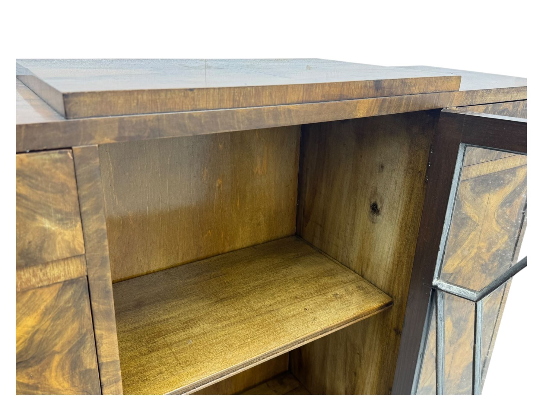 Art Deco burr walnut drinks cabinet, geometric central glazed astragal door enclosing two fixed shelves, flanked by symmetrical bookmatched veneered cupboards with drawers above 