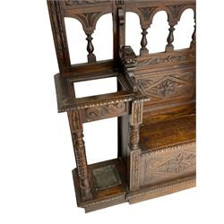 Victorian heavily carved oak hall-stand, moulded cornice with foliate carved decoration over bevelled mirror back, drop centre with hinged box seat flanked by stick or umbrella stands, scrolls and foliate carved decoration