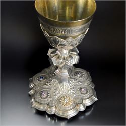 20th Century silver plated Gothic chalice, embossed throughout with fleurs de lis, foliate and bead decoration, on a knopped stem with flared and cusped foot, inset with three amethyst and two blue paste stones and applied paste and split pearl brooch, engraved beneath 'In Memory of my Mother R.I.P ... Aug 15th 1937, H23cm