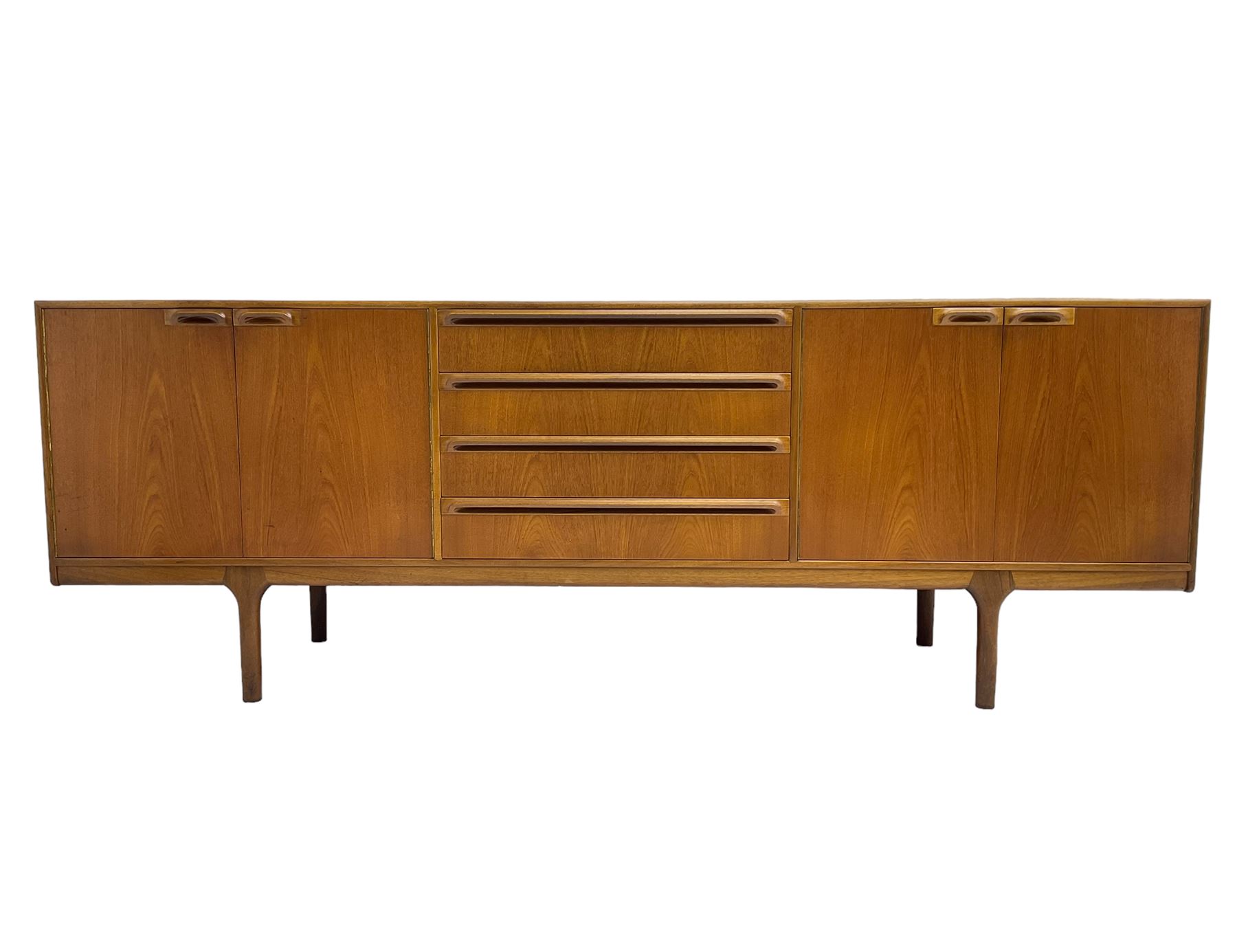 Tom Robertson for AH McIntosh & Co of Kirkaldy - mid-20th century teak sideboard, fitted with four central drawers, flanked by cupboard enclosing shelves and sliding tray, raised on cylindrical supports