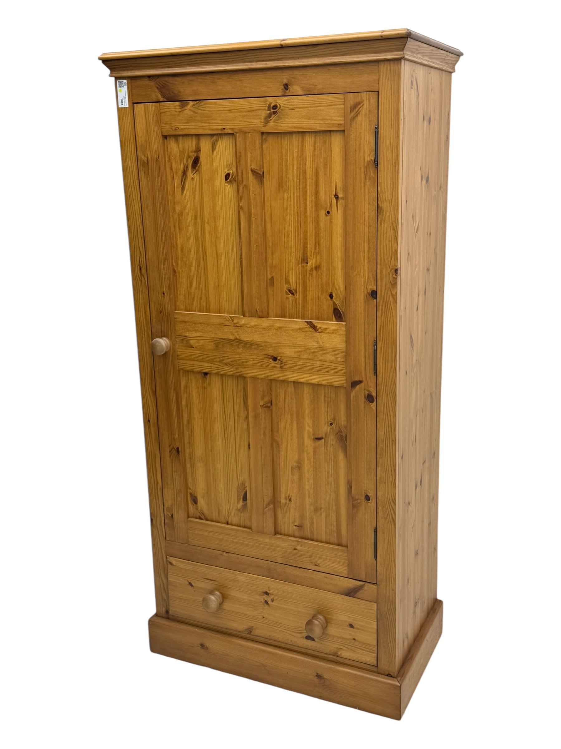 Pine single wardrobe, enclosed by single panelled door, fitted with single drawer, on plinth base 