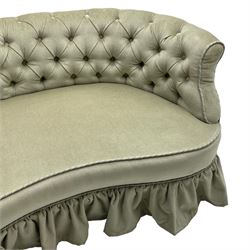 Victorian mahogany framed kidney shaped two seat settee, low curved back and sprung seat upholstered in buttoned pale pearl green fabric with pleated skirt, raised on turned supports with castors