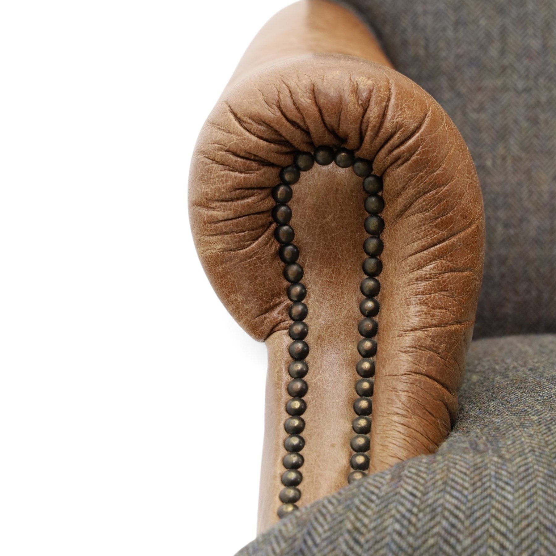 Tetrad - 'Taransay' Harris Tweed and tan leather club armchair, Howard shape with reclined back over deep seat and rolled arms with studwork, raised on turned front supports with castors, the sides and arms upholstered in tan leather with seat and back in herringbone-stitched Harris Tweed