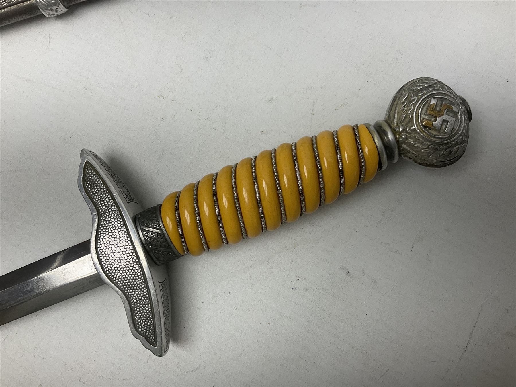 WW2 German Luftwaffe 2nd Pattern Officers dress dagger, with unmarked 25.5cm double edged steel blade, wire-bound pale orange/yellow celluloid grip, globular  pommel with oak leaves and traces of gilding, Luftwaffe eagle cross guard; in beaded scabbard with two suspension rings L43cm overall
