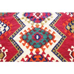 Persian Qashqai crimson ground rug, the central narrow ivory field decorated with repeating hooked geometric lozenges in multicolours, with a densely decorated guard band