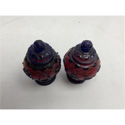Two Chinese Peking glass baluster vases with covers, the blue overlay carved with insects, fish and foliate motifs on red ground, with seal mark beneath, H13cm