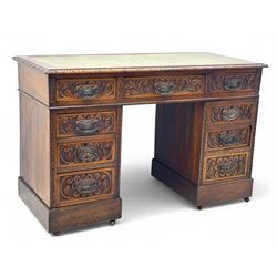 Late 19th century carved oak twin pedestal desk, rectangular top with inset leather writing surface, fitted with nine drawers, carved with scrolling foliate decoration, in three sections