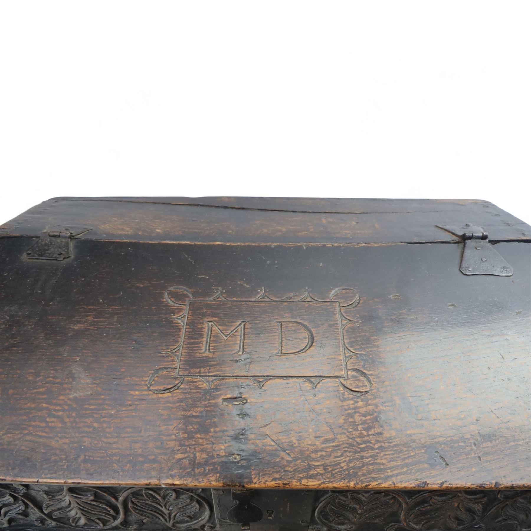 18th century carved oak Bible box on stand, the sloping lid with incised initials ‘MD’ and iron strap hinges, the front carved with stylised leaf and scroll panels enclosing central iron lockplate, on stand with gadrooned frieze, turned legs and plain stretchers