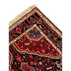 Persian Hamadan red and indigo ground rug, central lozenge medallion with extending poles, the field decorated with interlaced branches and flowerheads, guarded border with stylised floral motifs