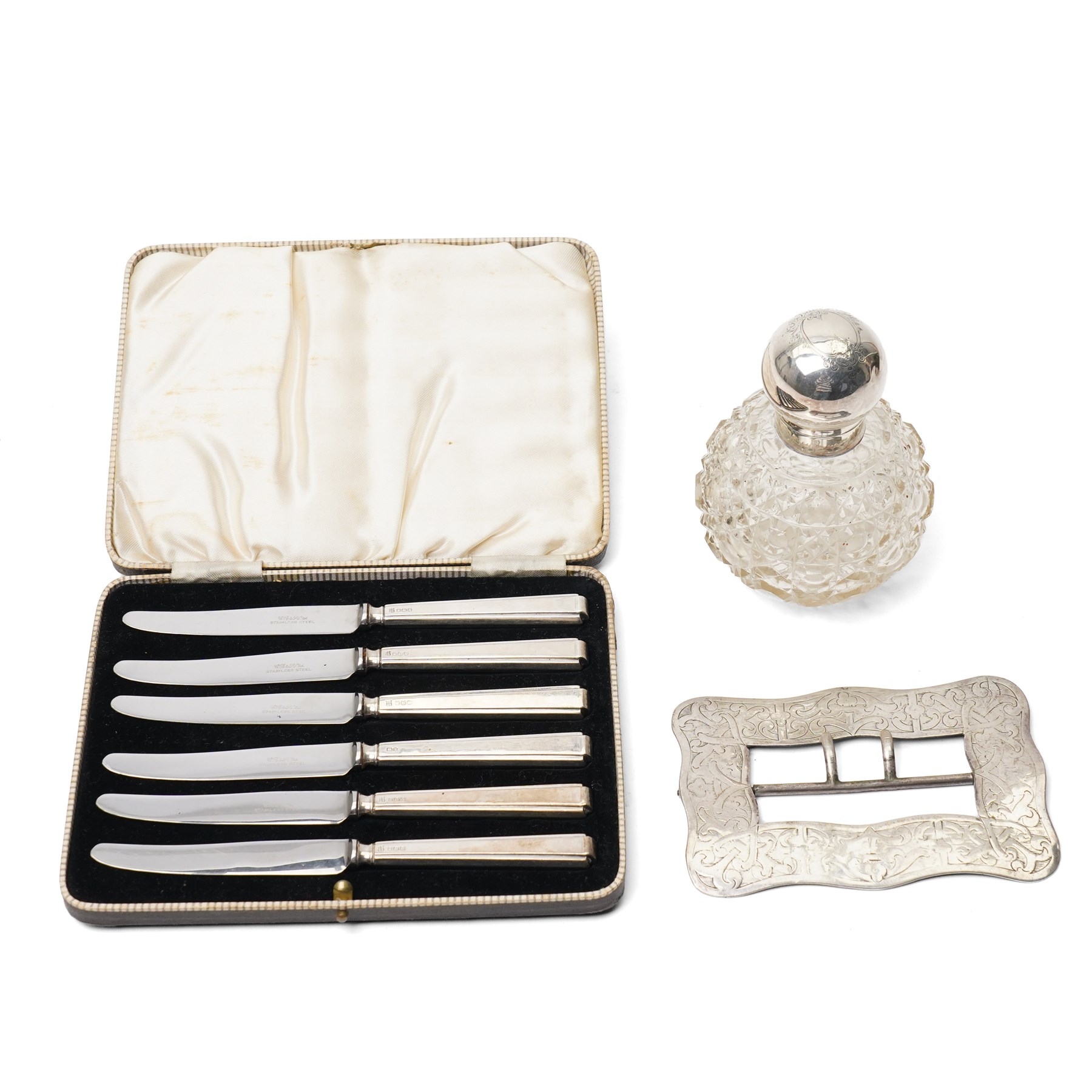 19th century engraved silver buckle 13cm x 9cm, the reverse engraved 1849, unmarked but tests 90 standard, cut glass globe scent flask with silver cover Sheffield 1911 and a cased set of six silver handled tea knives