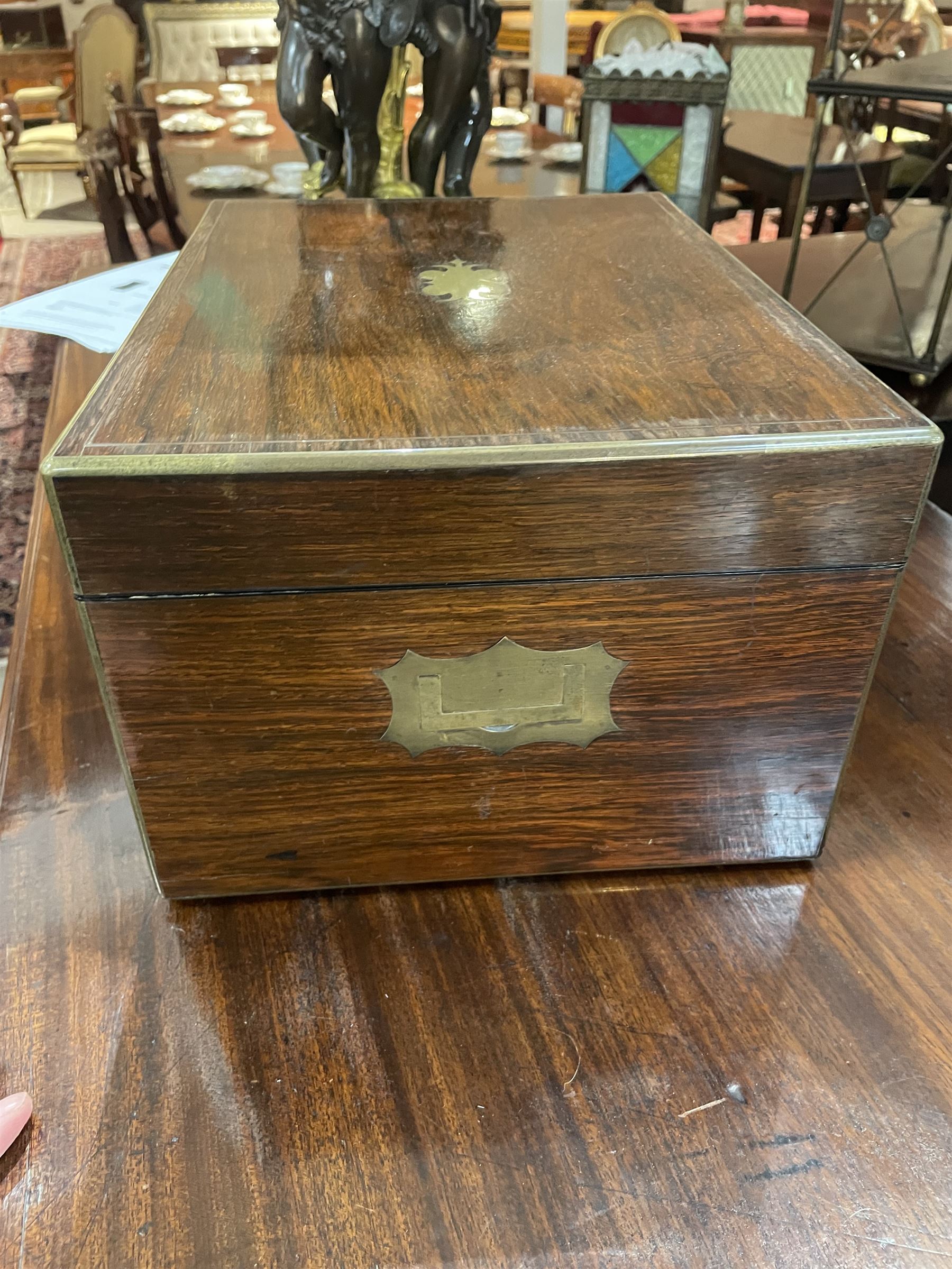  Victorian brass inlaid rosewood dressing table box, retailed by F.L. Hausburg, Liverpool, the lid centred by a brass cartouche, opening to reveal letter store to lid underside, above a fitted interior, with ten mounted cut glass jars, bottles and manicure set, within lift out leather trays, above jewellery drawer, with key, H17cm D24cm