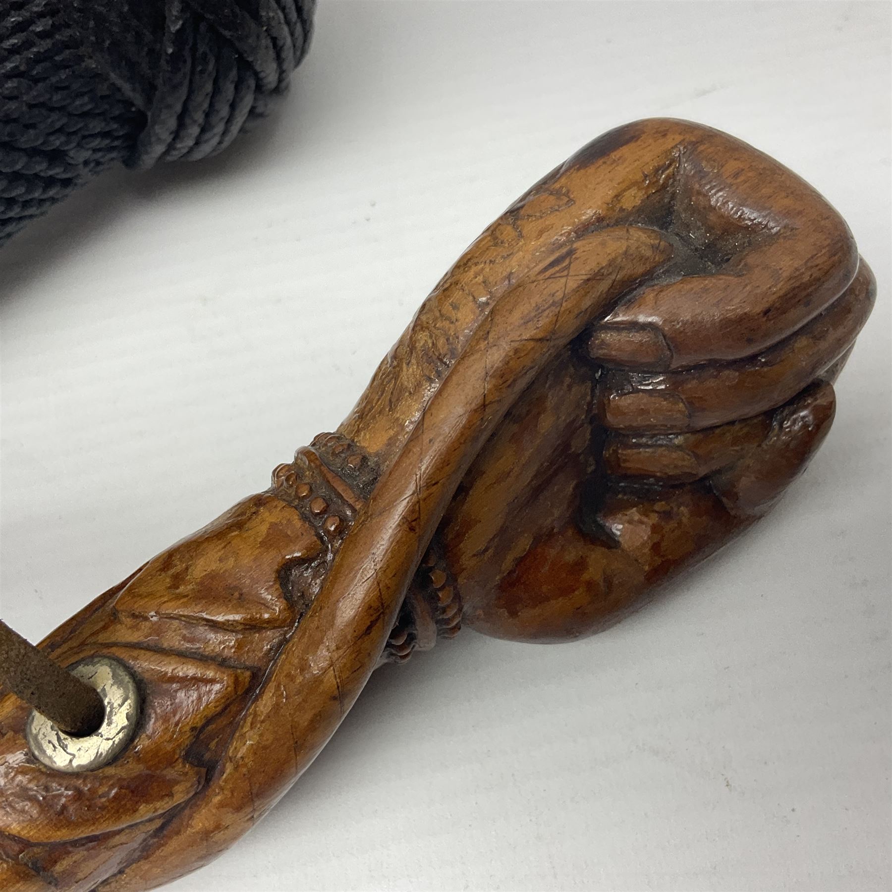 19th century wooden walking stick, the handle carved as a snake within a clenched fist, the cane carved with foliate and cross hatched decoration, with a metal spike to base, together with a turned wooden walking stick, with lacquered rope nautical knot handle, tallest L96.5cm