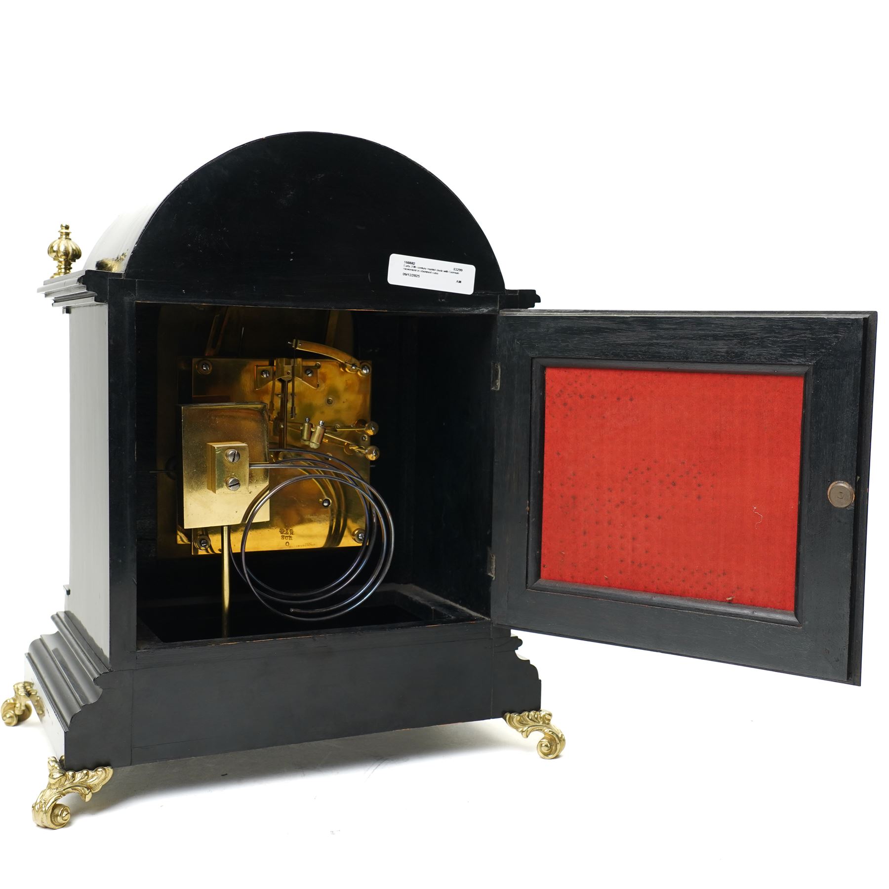 Winterhalder & Hoffmeier-8-day early 20th century mantel clock with an ebonised finish, break arch pediment and two matching brass finials, conforming glazed door with a cast brass bezel flanked by reeded quarter pilasters, on a moulded plinth with scroll feet, brass dial with cast spandrels and strike/silent and pendulum regulation dials to the arch, matted dial centre with a silvered chapter, Roman numerals  and gothic steel hands, dial pinned to a quarter striking movement sounding the quarters on two gongs and hours on one. With Pendulum.
