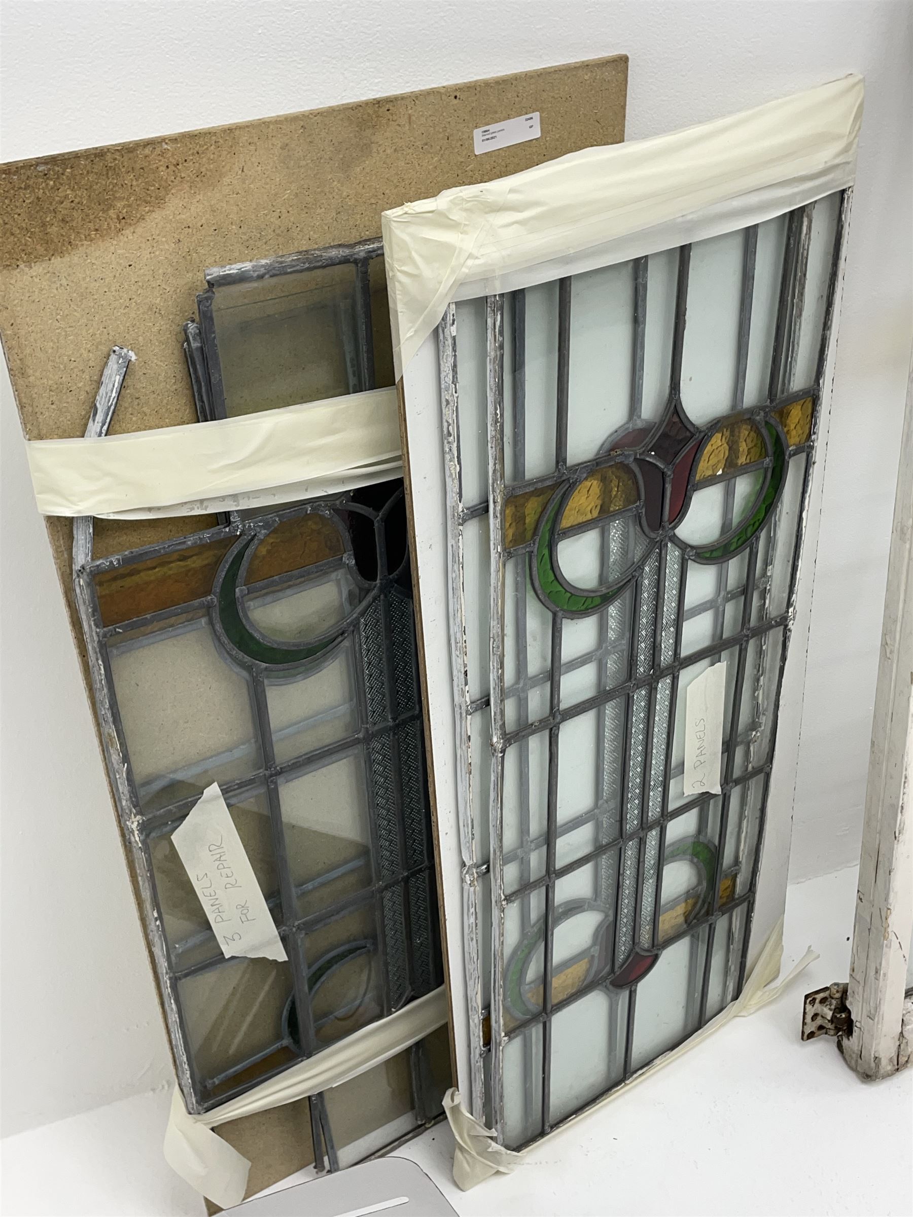Collection of stained and leaded glass windows and panes, stylised floral design, various sizes, the largest window measuring 55cm x 112cm (including wooden frame)