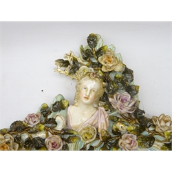  19th century Meissen style mirror, the rocaille frame heavily applied with roses amongst foliage, two winged cherubs below a maiden, H59cm x W37cm   