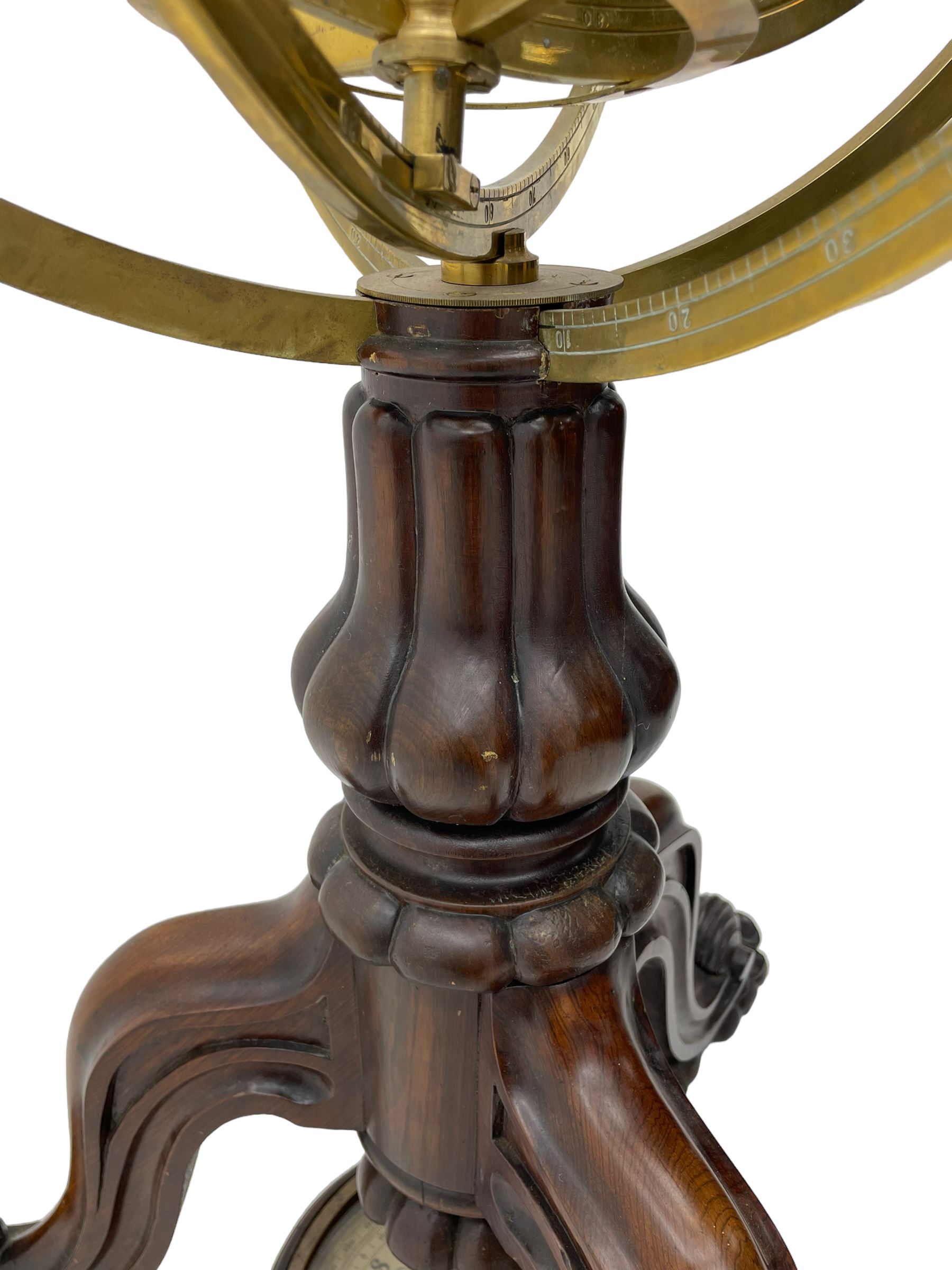 19th century brass terrestrial armillary sphere on rosewood base, lobe carved column on three splayed supports with scrolled carved terminals, the supports united by circular compass with turned stretchers
