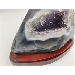 Amethyst crystal geode cluster, with well-defined crystals of various sizes, upon a carved wooden stand, H12cm, L20cm