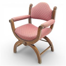 Late Victorian oak x-frame armchair, upholstered padded back and seat covered in pink patterned fabric with close studded borders, shaped downswept arms with scroll terminals, raised on curved x-frame supports with moulded scroll feet