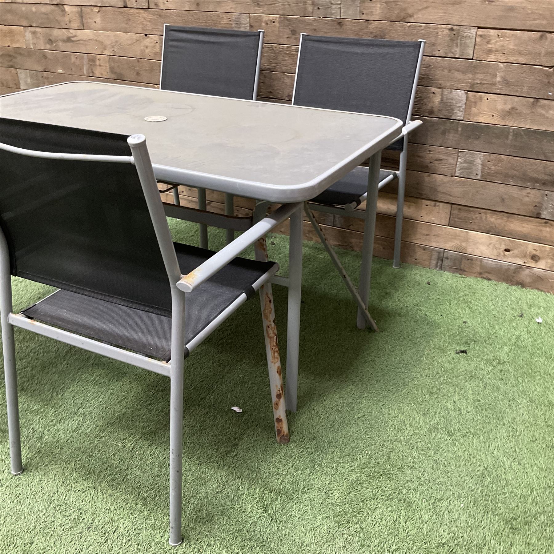 Rectangular metal framed garden table with glass top and four stackable chairs - THIS LOT IS TO BE COLLECTED BY APPOINTMENT FROM DUGGLEBY STORAGE, GREAT HILL, EASTFIELD, SCARBOROUGH, YO11 3TX