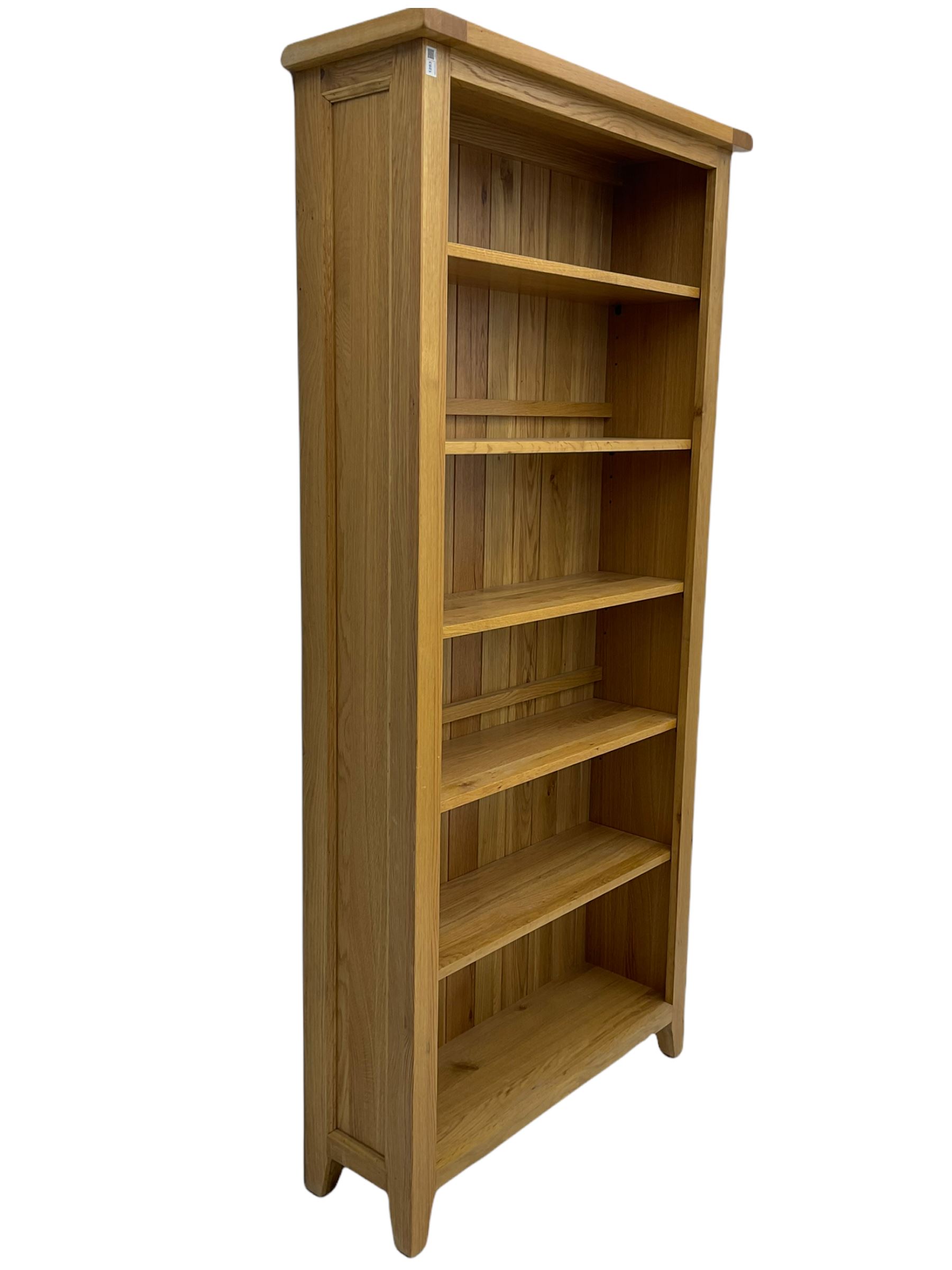 Tall light oak bookcase, fitted with five shelves The Furnishings