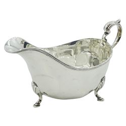 George V silver sauce boat, with part panelled body and scroll handle, upon three hoof feet, hallmarked E S Barnsley & Co, Birmingham 1916, including handle H10cm, approximate weight 6.52 ozt (203 grams)