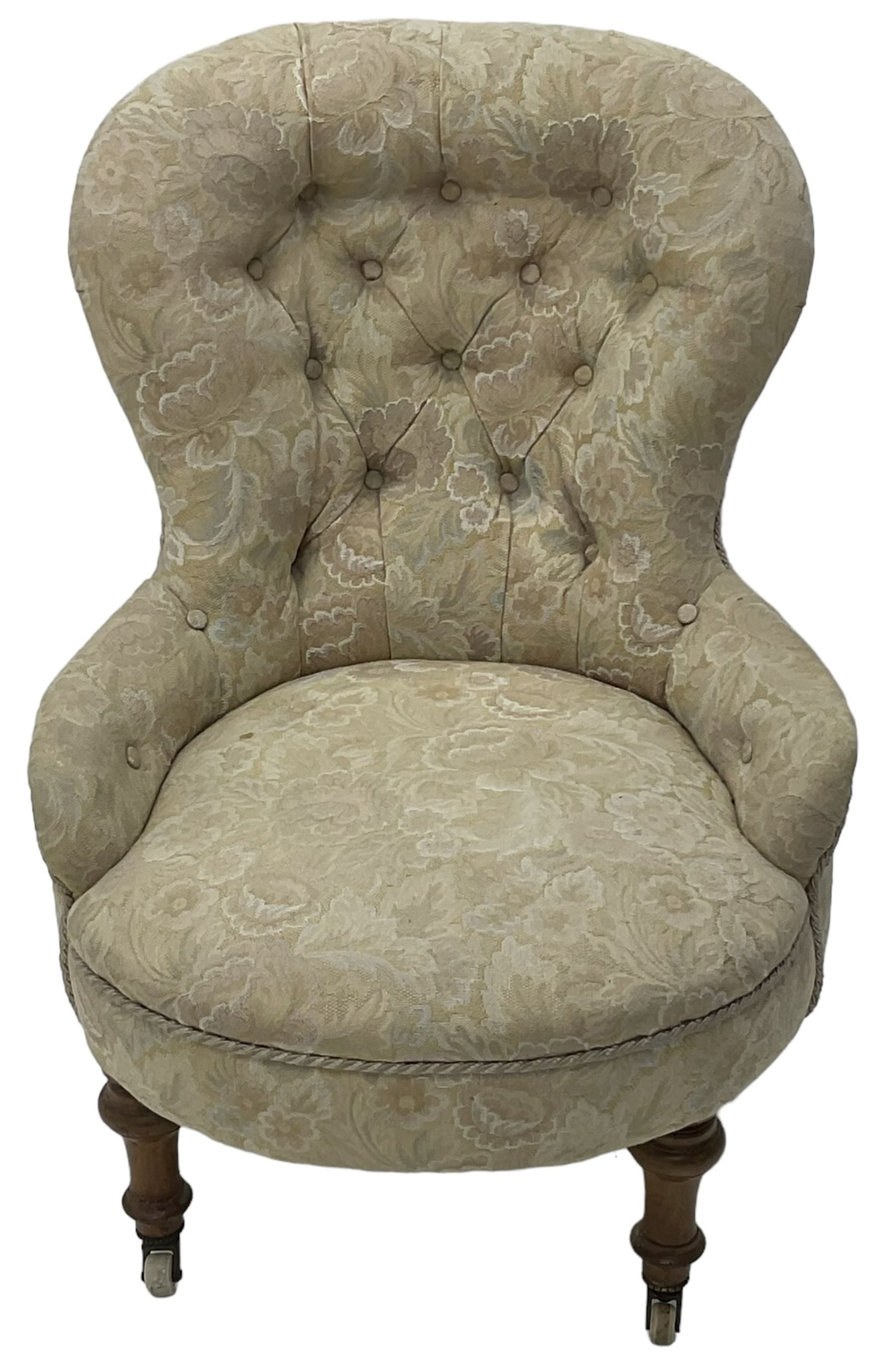 Victorian walnut framed nursing chair, upholstered in buttoned floral pattern fabric, on turned front feet 
