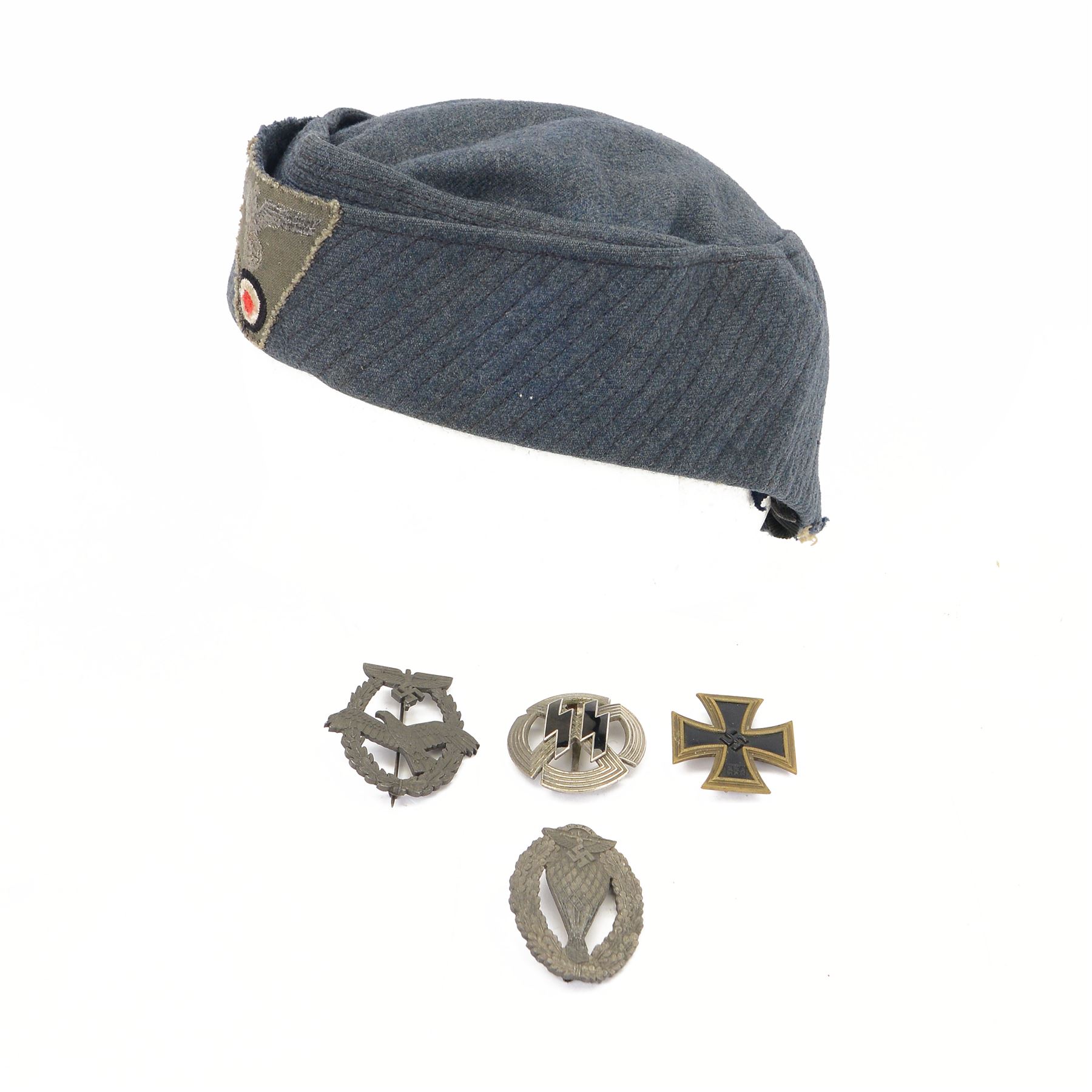 Four German style badges, including Iron Cross, German Proficiency SS runes badge, etc together with a reproduction German cap 