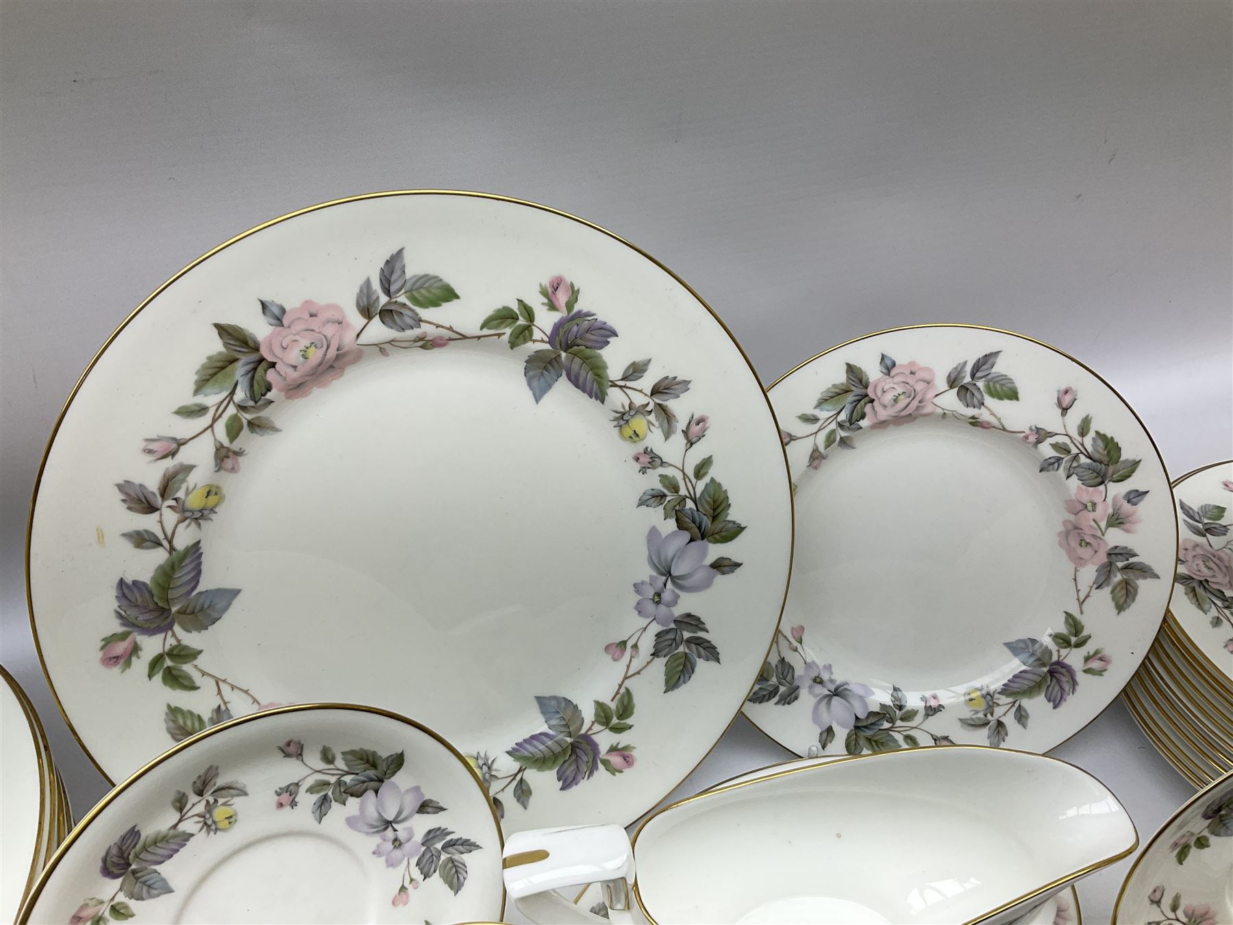 Royal Worcester June Garland pattern tea and dinner wares, comprising thirteen dinner plates, twelve dessert plates, twelve side plates, six twin handled soup bowls and six saucers, six small bowls, sauce boat and stand, thirteen teacups and fifteen saucers, open sucrier, and milk jug
