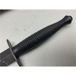 Third Pattern Commando Knife or Dagger with 17.5cm flattened diamond section blade and regulation black painted ribbed copper hilt with brass pommel nut; stamped William Rodgers Sheffield England to the cross-piece; in black painted brass mounted leather scabbard L34.5cm overall