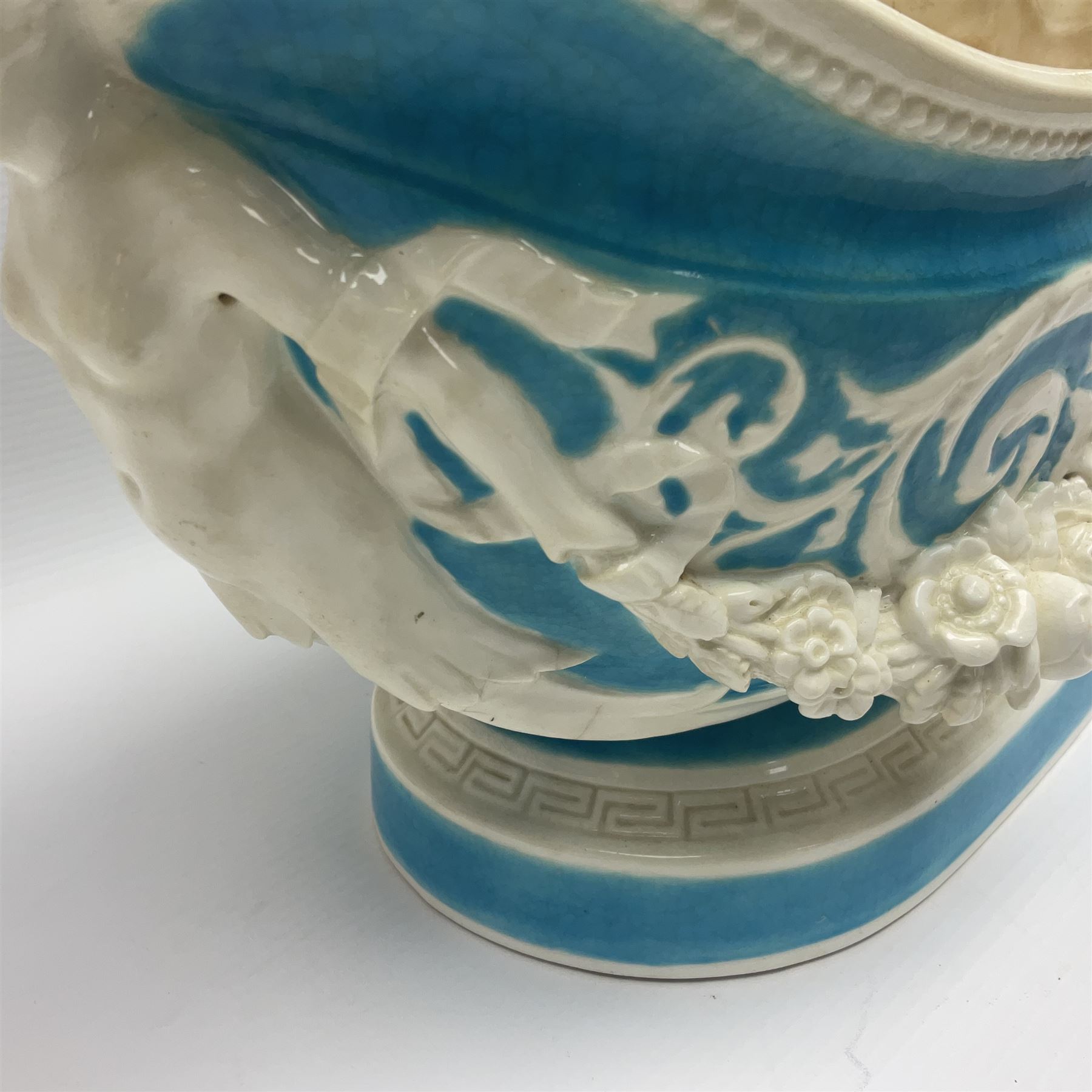 Rare 19th century Minton turquoise glaze majolica 'The Reader' flower holder, after Albert Carrier-Belleuse, modeled as a maiden in classical drapery reading whilst leaning against the pillar back of the helmet shaped cistern detailed with a caryatid and floral swags, the whole upon an oval plinth with Greek key border, with impressed marks beneath, H44cm
