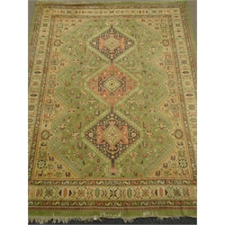  Large Persian style green ground rug, three central medallions, repeating border (353cm x 260cm) and a beige ground rug, patterned field (240cm x 174cm) (2)  