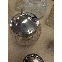 Collection of silver mounted glass bottles and jars, including decanter with etched floral decoration and silver collar, four scent bottles with silver caps, etc all hallmarked 