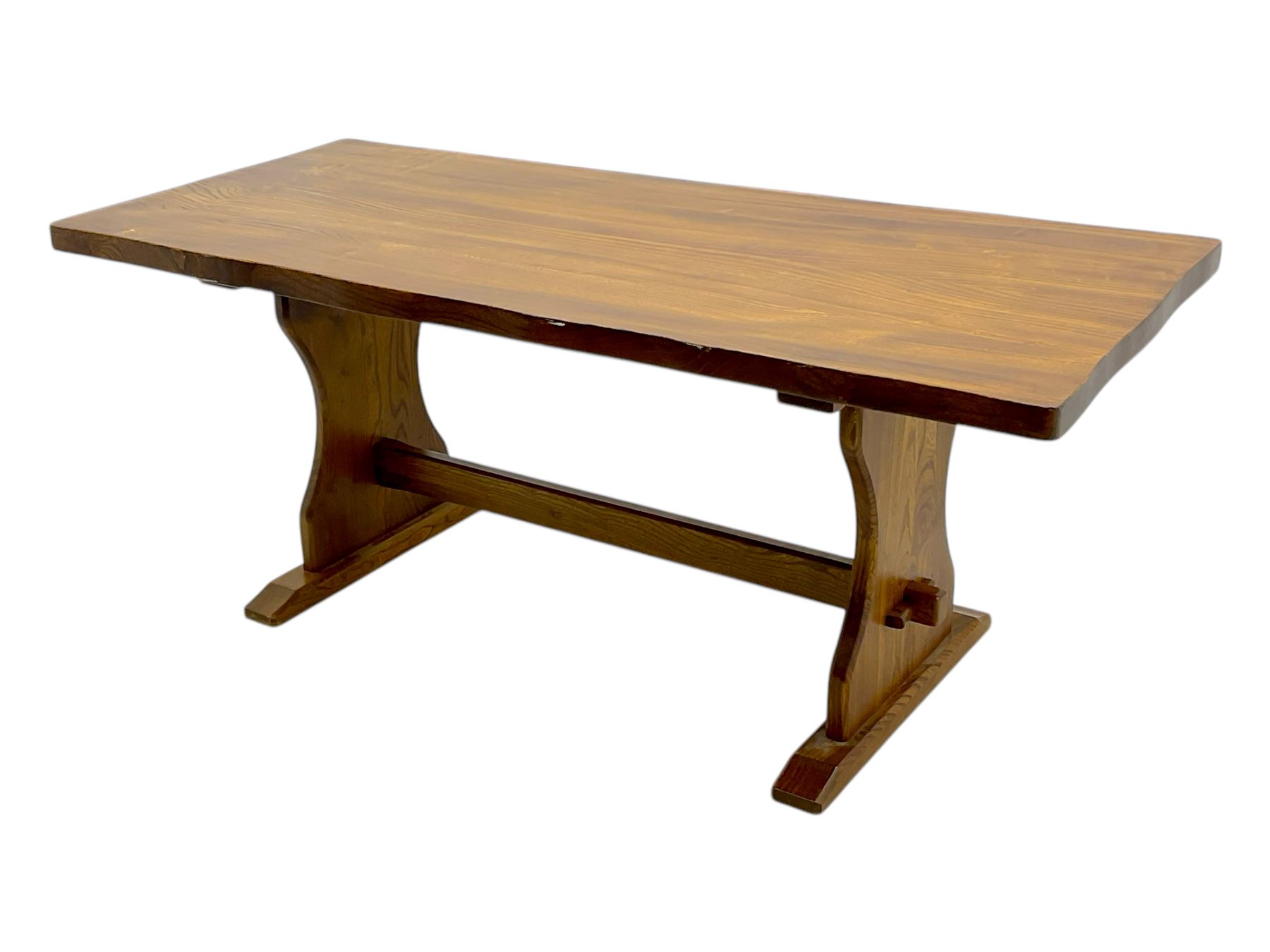 Late 20th century oak trestle table, rectangular top with naturalistic edge, supported by two curved pedestal bases united by central stretcher, on block feet