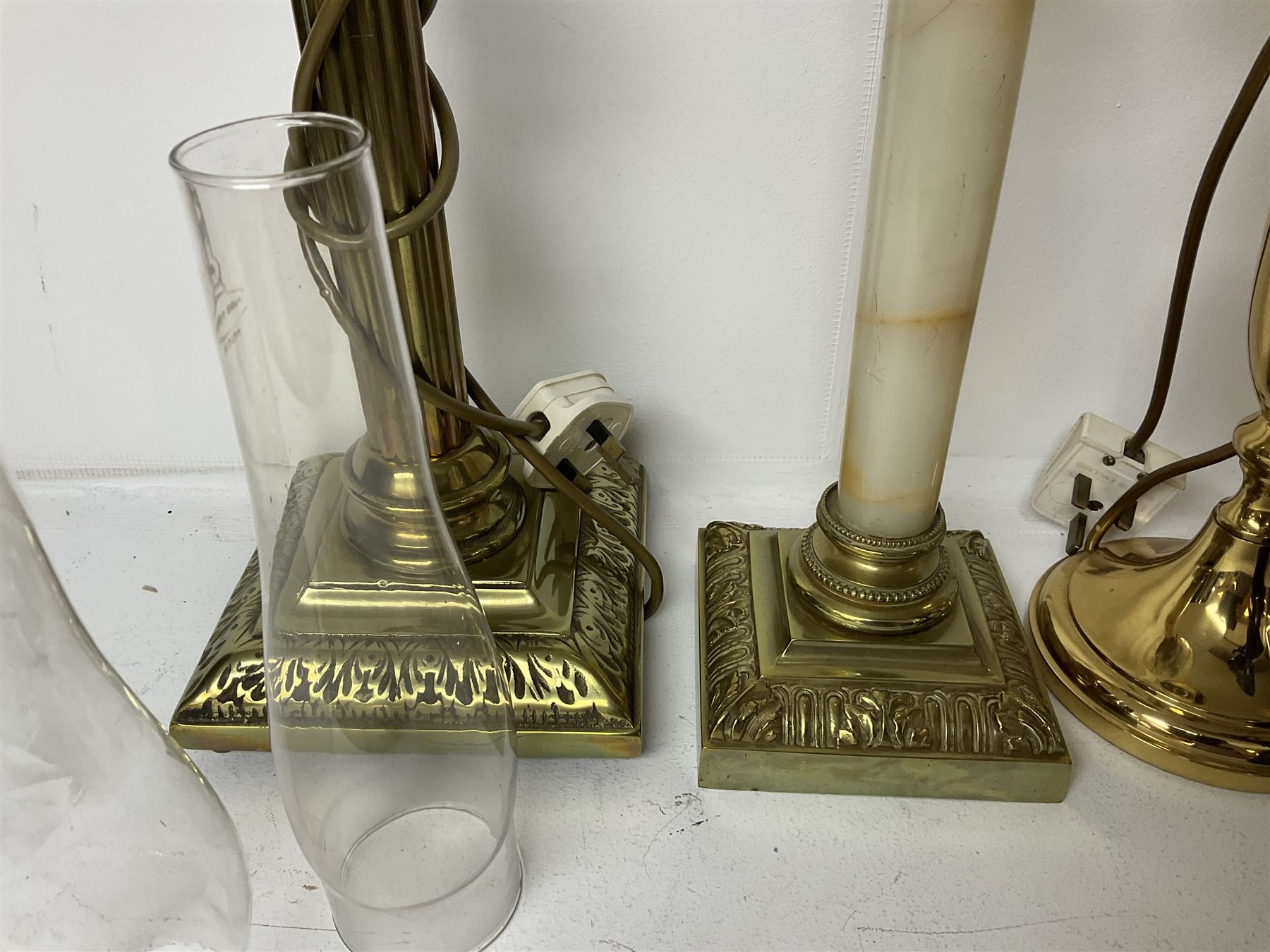 Oil lamp with frosted floral shade and cut glass reservoir, upon cast brass and marble base, together with a cast brass Corinthian column table lamp, pair of brass table lamps and a composite metal figure of a violinist 