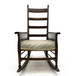 William Birch for Liberty & Co. - Arts and Crafts period oak ladder back rocking chair, the arms supported by a series of turned spindles, upholstered seat