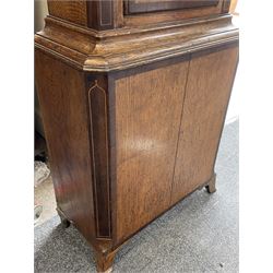 Early 19th century oak and rosewood banded longcase clock, scrolled pediment over stepped arch hood door, enamel painted dial indistinctly signed for a Penrith maker, 30-hour movement striking on bell