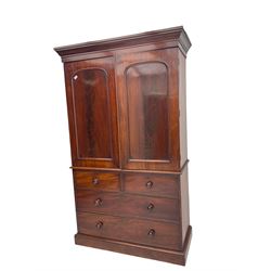 Victorian mahogany linen press, projecting moulded cornice, two doors with arched panels enclosed four linen slides, the lower section fitted with two short and two long drawers, on plinth base