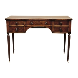  19th century Gillows style mahogany dressing table, rectangular inverted bow break front top with figured banding, curved drawer and four small drawers, knee hole apron, on four slender reeded supports with brass cups and castors, W112cm, H78cm, D50cm  
