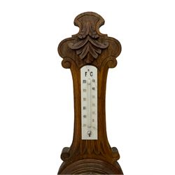 A carved oak cased aneroid barometer with a 5” register, measuring barometric pressure from 26 to 31.9 inches, weather predictions written in gothic capitals and lower-case script, with a steel indicating hand and brass recording hand within a brass bezel with a flat bevelled glass, with a mercury thermometer recording the temperature in degrees Fahrenheit and Celsius.



