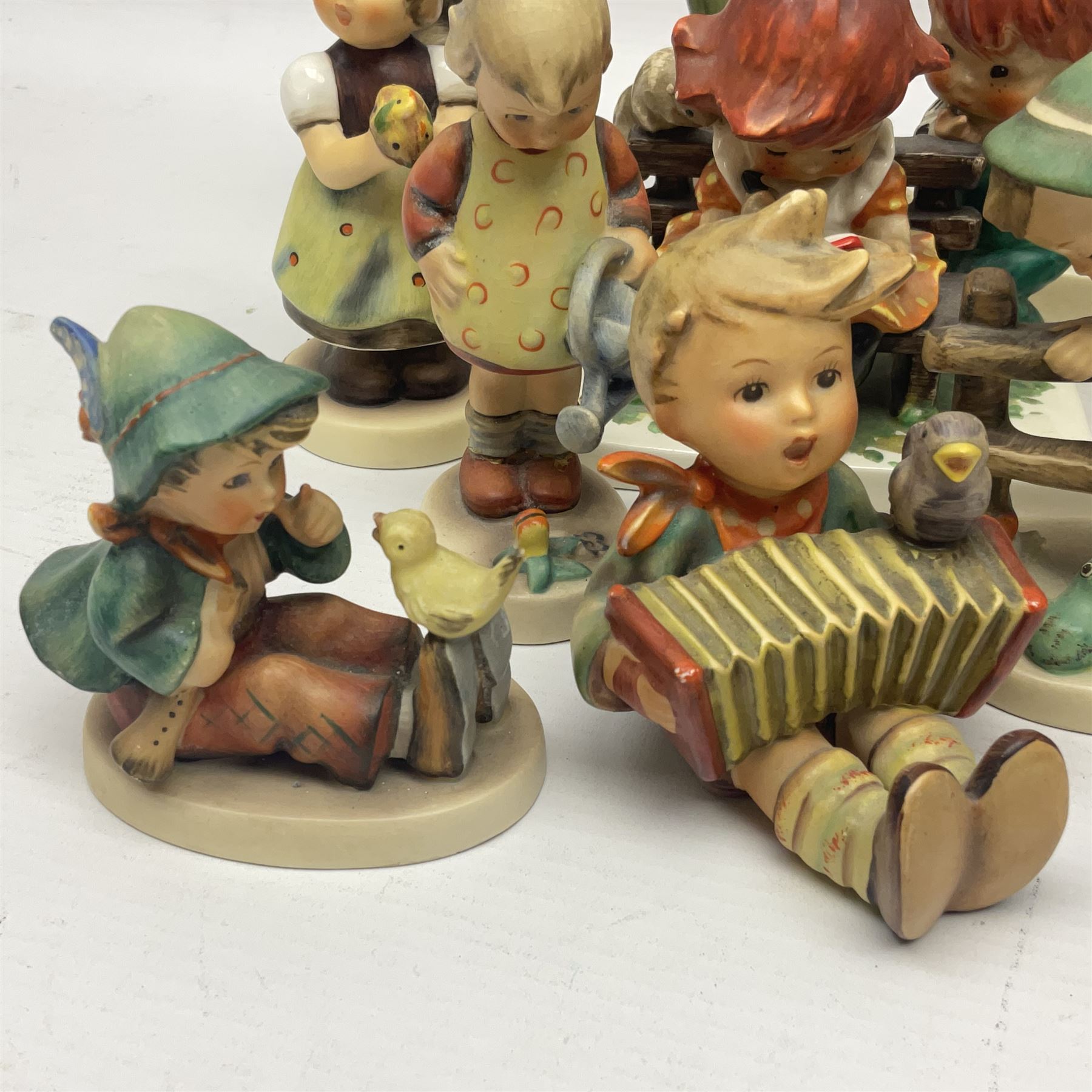 Sixteen Goebel Hummel figures, including Charlot A Young Man's Fancy, Stormy Weather and Bookworm, all with impressed and printed marks beneath