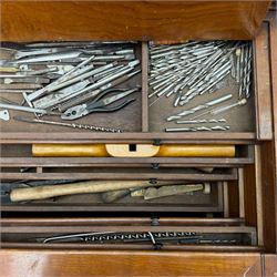 20th century black painted camphorwood lined tool chest, rectangular hinged lid over moulded edge, black painted exterior with iron straps and carry handles, the interior fitted with sliding lidded trays and drawers with turned handles, containing an assortment of hand tools