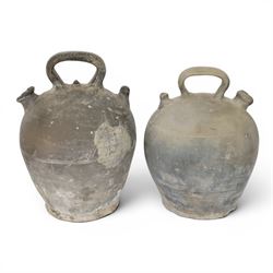 Four 20th century Spanish blackened earthenware botijo or cruche vessels, each of typical baluster form with central loop handle and opposing spout, impressed marks to handles, tallest example H31cm