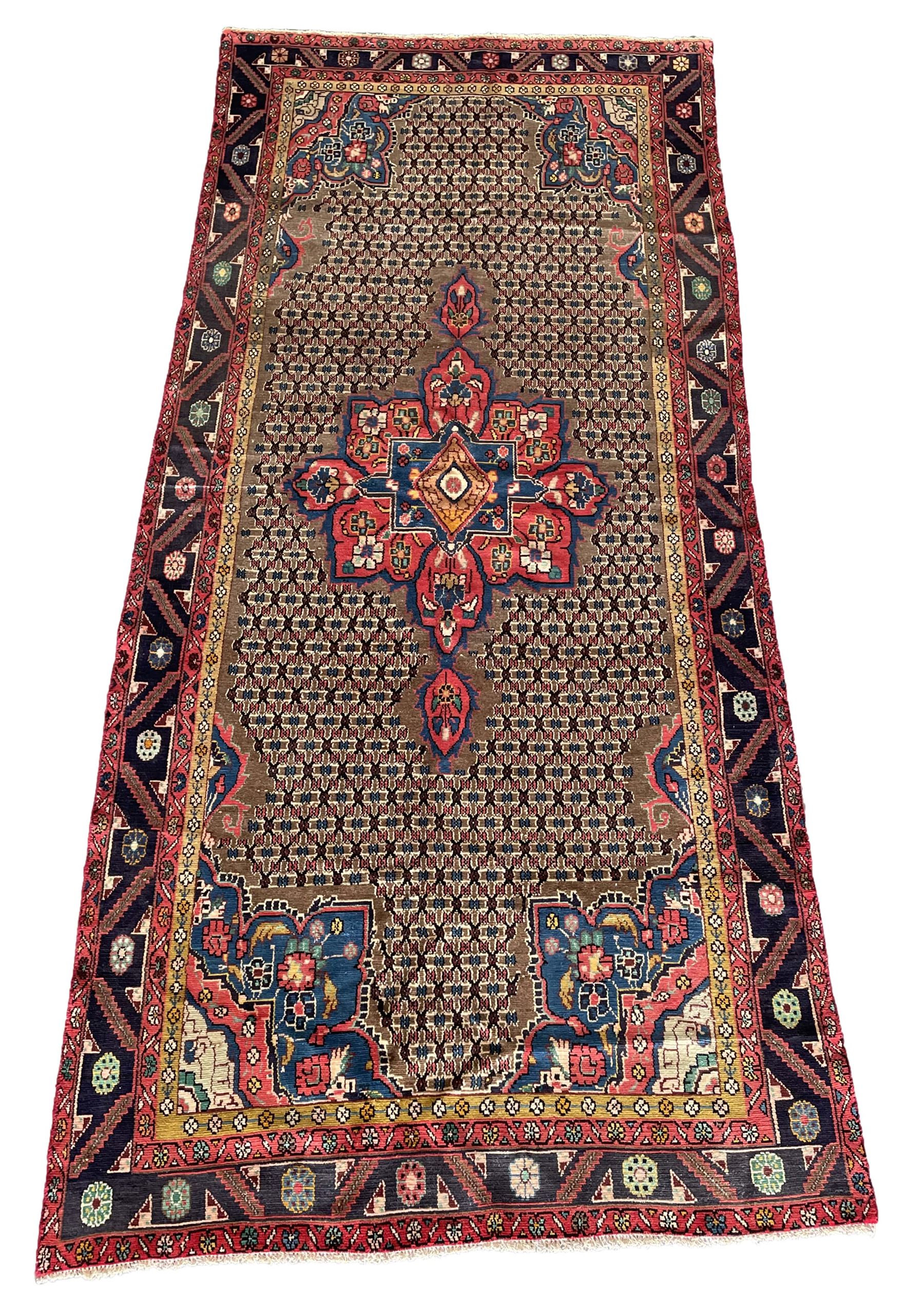 Persian Hamadan rug, the rosette pole medallion on a pale field decorated with stylised motifs, the blue band border decorated with stylised flower heads